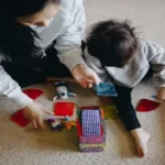 Developmental Red Flags in Babies and Toddlers (0–3 Years): Warning Signs by Age Developmental red flags 0 to 3 years: mother playing with her toddler using colourful educational toys