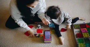 Developmental red flags 0 to 3 years: mother playing with her toddler using colourful educational toys